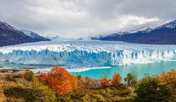 Glacier with mountains and autumnal forest